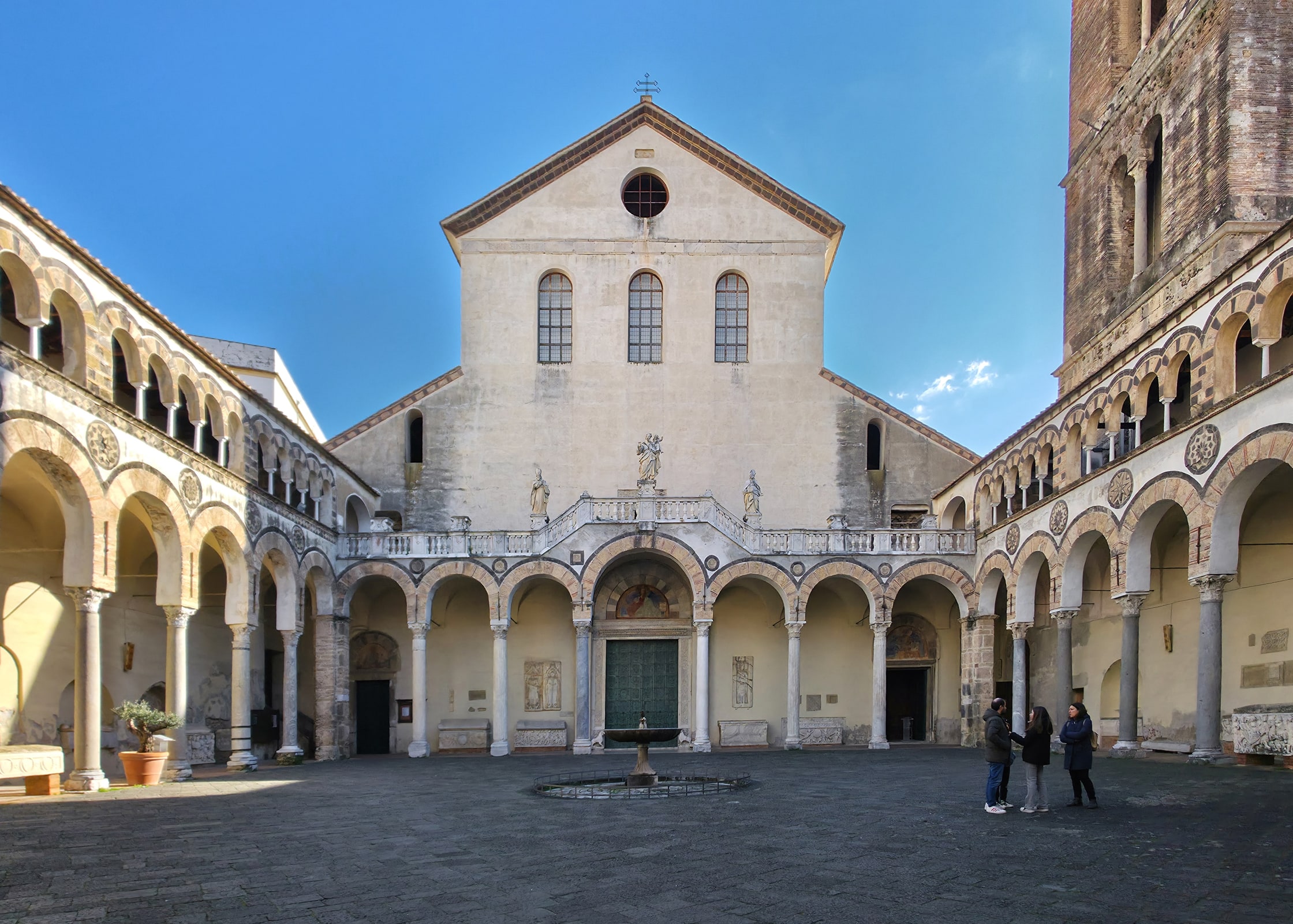 The pale stone facade and arched entrance of Salerno Cathedral in Campania, Italy.