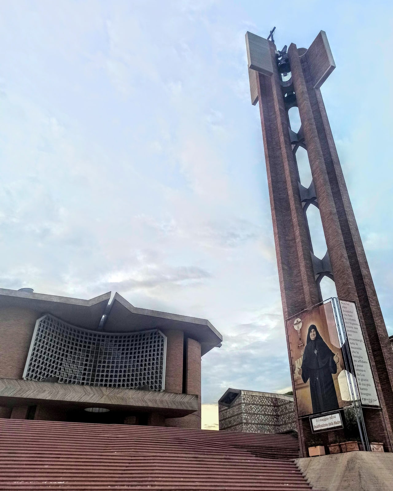 The modern Basilica and Sanctuary of Merciful Love, its broad staircase, and bell tower at Collevalenza, Italy.