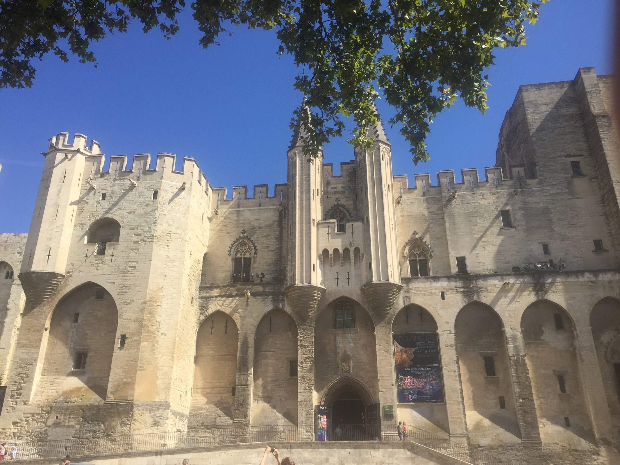 Stone towers and Gothic exterior of the Palais des Papes in Avignon, France.
