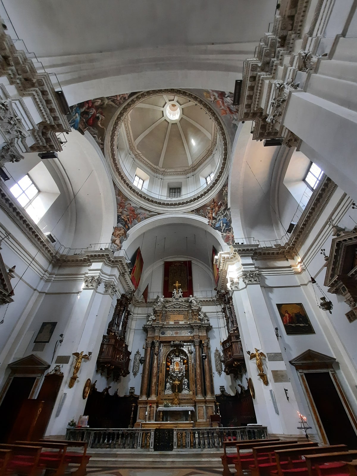 The high altar, white stucco interior, and painted dome of Santa Maria in Provenzano in Siena.